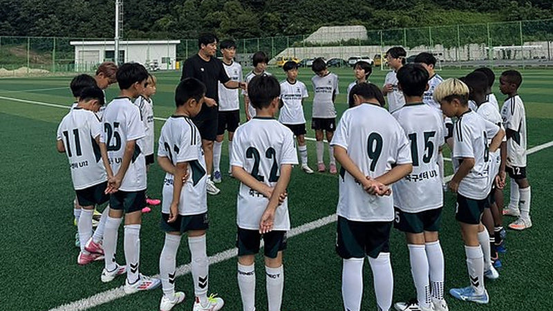 Youth soccer team in custom white and green uniforms huddling on the pitch — ZHONGKANG factory-made kit